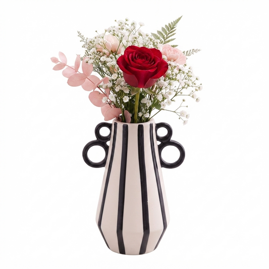 Modern black and white striped ceramic flower vase on a white table.