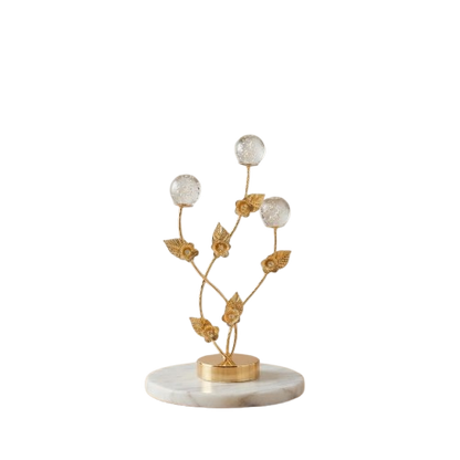 Golden decorative flower branch showpiece with crystal bubble spheres on a clean neutral background.