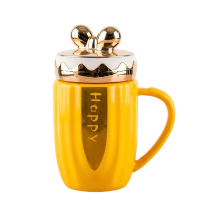 A bright yellow ceramic mug by Gift by Hamza featuring gold "Happy" text, metallic gold accents, and a cute golden bow-shaped lid.