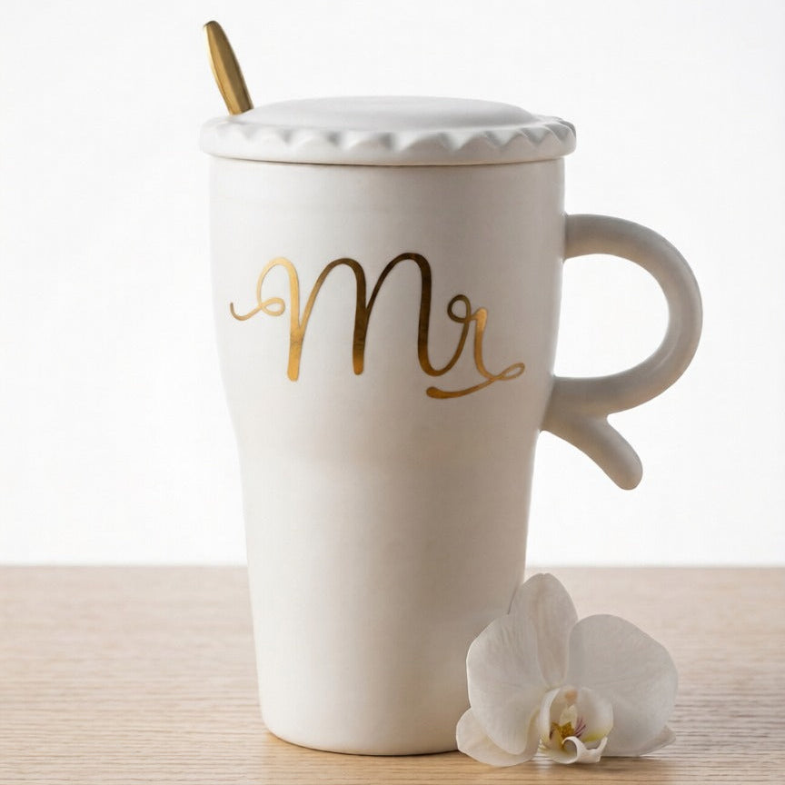 A sophisticated white ceramic mug by Gift by Hamza featuring 'Mr' in gold calligraphy, complete with a matching lid and gold spoon.
