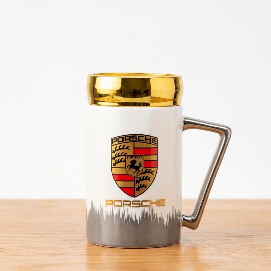 A high-end white ceramic mug by Gift by Hamza with the Porsche crest, elegant gold rim, and a modern metallic handle.