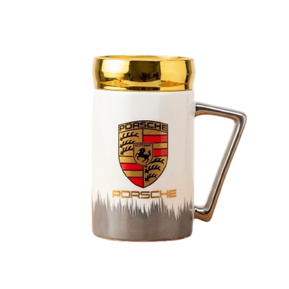 A high-end white ceramic mug by Gift by Hamza with the Porsche crest, elegant gold rim, and a modern metallic handle.