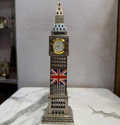 A detailed silver Big Ben clock tower replica with a functional clock face and a Union Jack flag emblem, standing on a white marble surface.