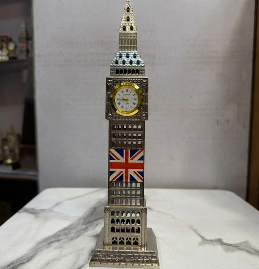 A detailed silver Big Ben clock tower replica with a functional clock face and a Union Jack flag emblem, standing on a white marble surface.