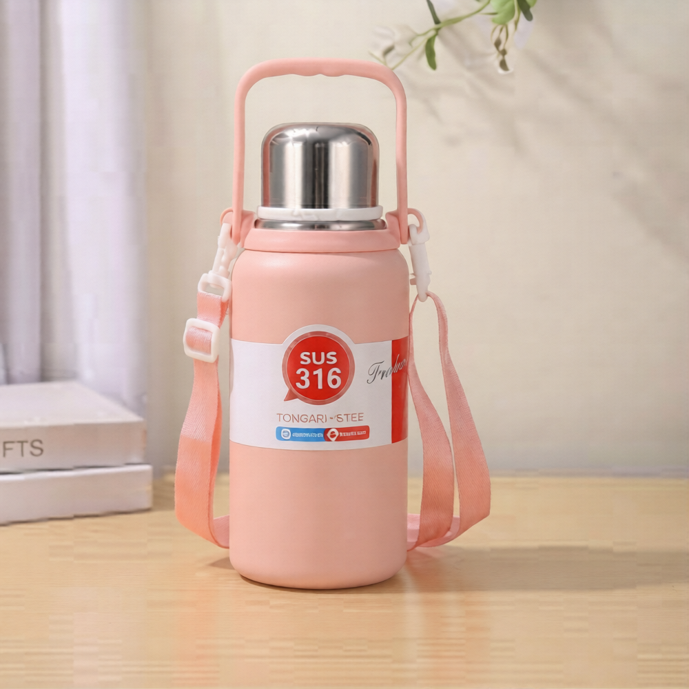 A pastel pink SUS 316 stainless steel insulated water bottle with a silver cap, top handle, and pink shoulder strap standing on a wooden surface.